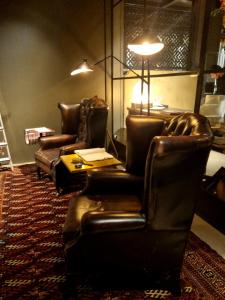 米兰Boutique Hotel Borgo Nuovo的客厅配有两张皮椅和一张桌子
