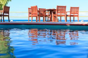 马洛洛时髦鱼滩和冲浪度假酒店的一组椅子和一张桌子,旁边是游泳池