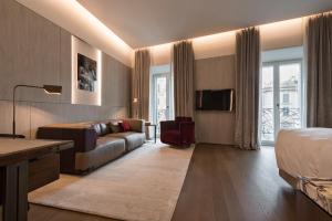 罗马Fendi Private Suites - Small Luxury Hotels of the World的酒店客房设有一张沙发和一张床