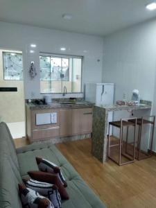 戈亚斯州上帕莱索Chapada Confort Flats的带沙发的客厅和厨房