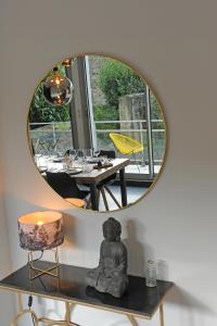 圣布里厄Les Briochines - Cocon cosy en plein centre-ville的墙上的镜子,桌子和饭厅
