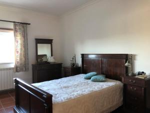 Moimenta da SerraQuinta das Oliveiras的一间卧室配有一张带木制床头板和镜子的床