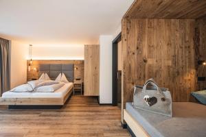 塞尔瓦迪加尔代纳山谷Hotel Wolf的一间卧室设有一张床和木墙