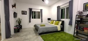 七岩七岩瑞士简易别墅度假屋的一间卧室配有一张带绿色枕头的床