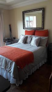 比勒陀利亚Genie's Nest 3的一间卧室配有一张带红色床头板和镜子的床