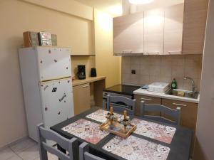 约阿尼纳HOME SWEET HOME的厨房配有桌椅和冰箱。
