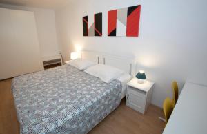 科佩尔Sobe pri Anici的卧室配有一张床,墙上挂有绘画作品