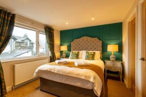 温德米尔Holly Lodge Guest House with FREE off site health club的一间卧室配有一张带绿色床头板的床和窗户