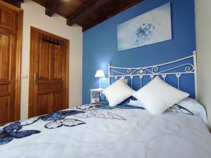 Prádena del RincónDel Abuelo Casa Rural的一间卧室配有一张蓝色墙壁的床