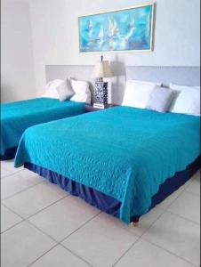 圣卡洛斯Condominio Posada 314 San Carlos的卧室内的两张蓝色床罩