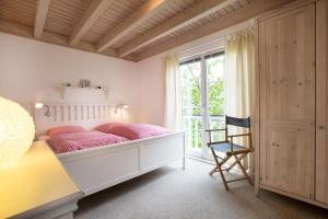 希尔克道夫Pippi´s Ostseetraum的一间卧室配有带粉红色枕头的床和窗户。
