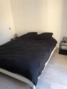 卡庞特拉Villa avec vue campagne的卧室内的一张带黑色棉被的床