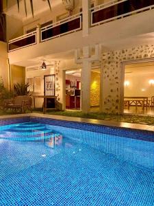 科托努L'Oasis Guesthouse的房屋中间的大型游泳池