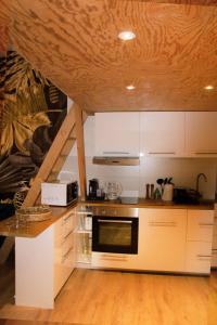 南特Chrysalide cocon的厨房配有白色橱柜和炉灶烤箱。