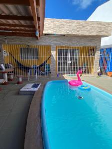 伊塔马拉卡Casa De Praia em Itamaracá的水中一个粉红色天鹅的游泳池