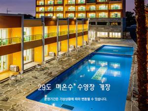 济州市Suandsu Resort的大楼前的酒店游泳池