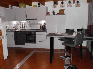 纽哈灵吉塞尔Möwennest的厨房配有白色橱柜和桌椅