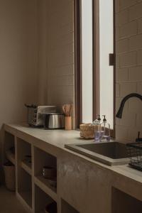 坎佩切Narrativ Lofts -Solario- Charming Historic Escape的厨房柜台设有水槽和微波炉