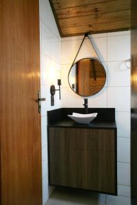 坎巴拉Cabanas Charme da Serra的一间带水槽和镜子的浴室