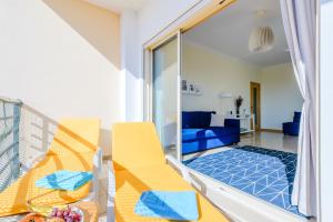 阿尔布费拉Ocean view Apartment with 3 spacious Terraces, 2 Swimming pools & Tennis court的客房设有带黄色椅子的阳台和客厅。