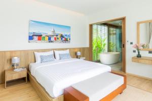 邦涛海滩Ananas villa Shambala grand Cherng Talay的一间卧室设有一张大床和一个浴缸