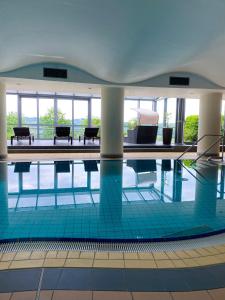 贝格诺伊施塔特菲尼克斯酒店的大楼内带桌子和长凳的游泳池