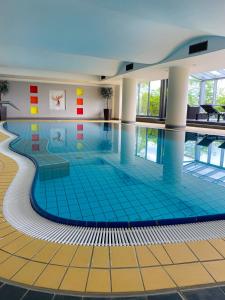 贝格诺伊施塔特菲尼克斯酒店的大楼内一个蓝色瓷砖的大型游泳池