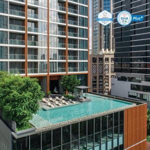 曼谷曼谷橡树套房酒店的一座高楼建筑顶部的游泳池
