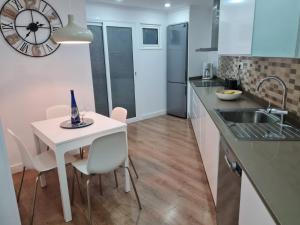 大加那利岛拉斯帕尔马斯Your Canary Home的厨房配有白色的桌椅和水槽