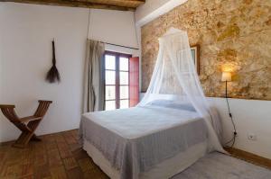 拉戈斯Casas na Vinha - Monte da Casteleja, Wine Estate - Eco Turismo Rural的一间卧室配有一张带蚊帐的床