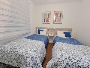 大加那利岛拉斯帕尔马斯Your Canary Home的配有两张蓝色和白色床单的床铺