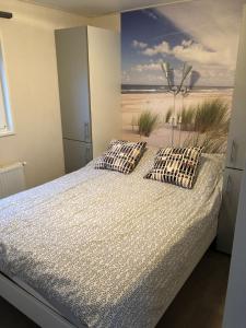 比伦Chalet Zeekraal的一间卧室配有一张床,享有海滩美景