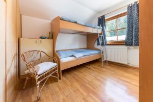 克拉尼斯卡戈拉Hiša nasproti sonca的一间卧室配有双层床、椅子和窗户。