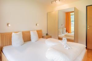 布雷根茨沃尔德地区奥苏珊公寓酒店的一间卧室配有两张床和镜子