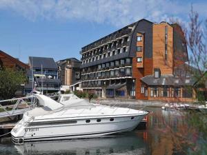 多维尔Studio avec vue mer splendide, Port-Deauville, proche Plage的坐在建筑物旁边的水中的小船