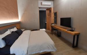 台南傅居52的一间卧室配有一张床和一张书桌及电视