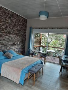 萨拉济La Croisee des Sentiers的一间卧室设有一张床和砖墙