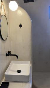 伊奥斯乔拉L Apothiki的浴室设有白色水槽和镜子