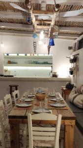 伊奥斯乔拉L Apothiki的一张带白色椅子的木桌和一间餐厅