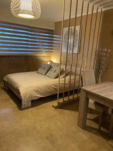 昂蒂布Beach-studio的一间卧室配有一张床、一张桌子和一个窗户。