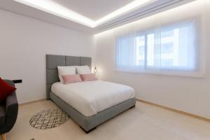 拉巴特Luxury one bedroom apartment - Best location的一间卧室配有带粉红色枕头的床和窗户。