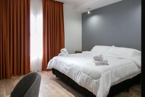 马科斯化雷斯Buongiorno B&B Hotel的卧室配有一张白色大床和一把椅子