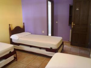 Las AlmuniasAlbergue Las Almunias的紫色墙壁客房的两张单人床