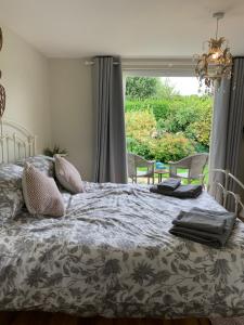 IbsleyNew Forest Chalet的卧室内的一张床铺,设有大窗户