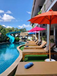 湄南海滩Samui Zenity的一个带椅子和遮阳伞的游泳池以及滑梯