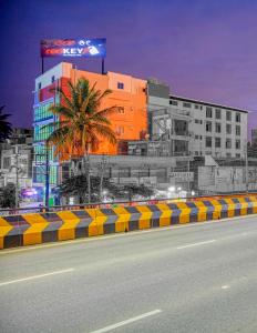 耶拉汉卡RedKEY Inn Bangalore Airport - Pick up & Drop Available 24x7的街道前有棕榈树的建筑