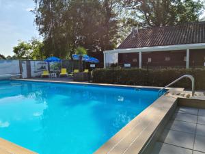Schoonebeekde4SeiZoentjes的房屋旁带长凳的游泳池