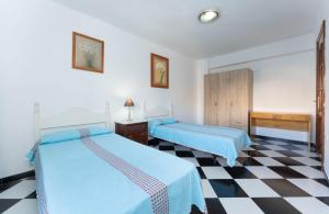马拉加Malaga downtown and beach apartment的一张位于带 ⁇ 形地板的客房内的两张床
