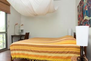 帕拉马里博Boom Apartments的一间卧室配有一张带彩色毯子的床