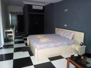 波多诺伏Mosaly Hotel PK10的卧室配有一张床,铺有黑白的格子地板。